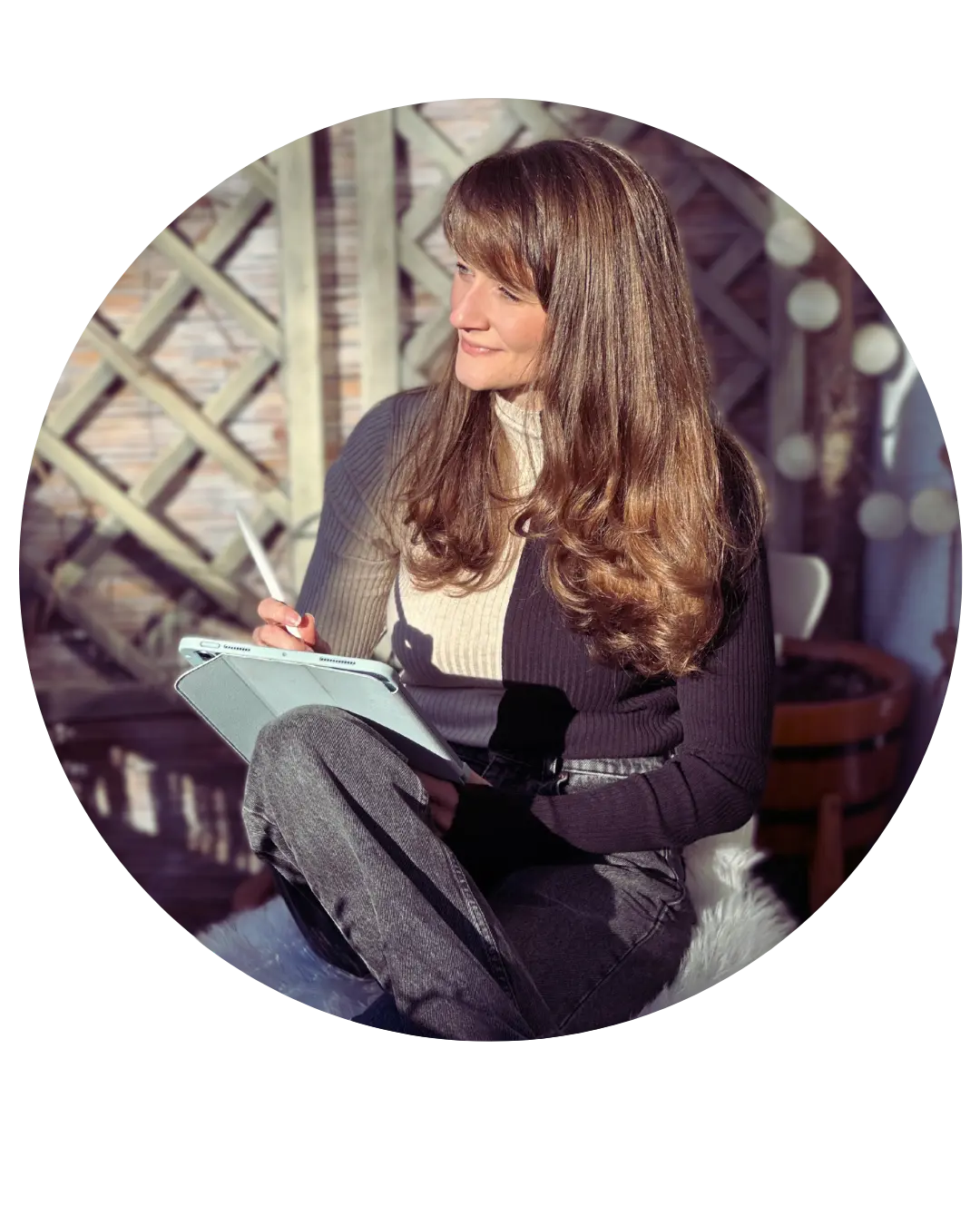 Judith Ring sitzt in der Sonne auf dem Balkon. Sie hat ein Schreibheft in der Hand und blickt in die Ferne.