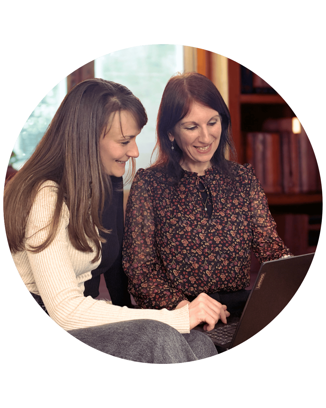 Judith zeigt einer Autorin auf einem Bildschirm etwas. Beide schauen fröhlich.